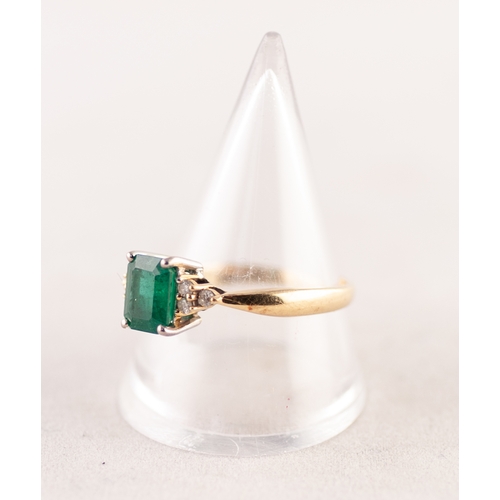 303 - A GOLD (no carat mark) RING, set with an emerald between shoulders set with six tiny diamonds, 4.1gm... 