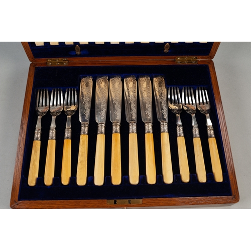 748 - AN EDWARDIAN OAK CASED SET OF TWELVE PAIRS OF PLATED FISH KNIVES AND FORKS, with bone handles