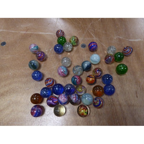 256 - APPROXIMATELY 40 LARGER SIXE PRE-WAR MARBLES with coloured swirl or silver glitter inclusions IN A T... 