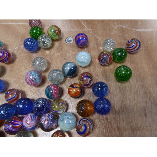 256 - APPROXIMATELY 40 LARGER SIXE PRE-WAR MARBLES with coloured swirl or silver glitter inclusions IN A T... 