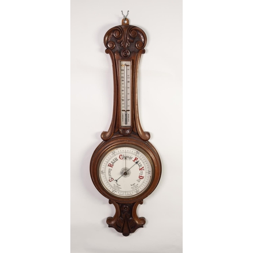 41 - LATE VICTORIAN CARVED WALNUT ANEROID BAROMETER, the 8” dial set beneath a mercury thermometer to the... 