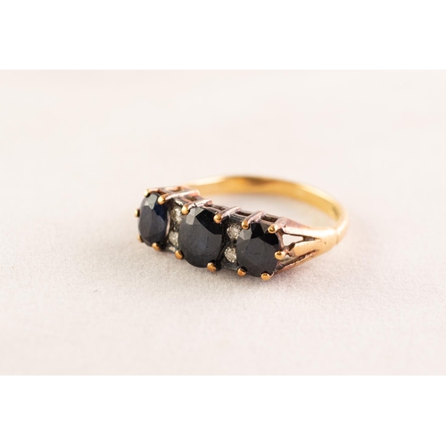 41 - 18ct GOLD RING set with three dark sapphires divided with four tiny diamonds, 4.1 gms