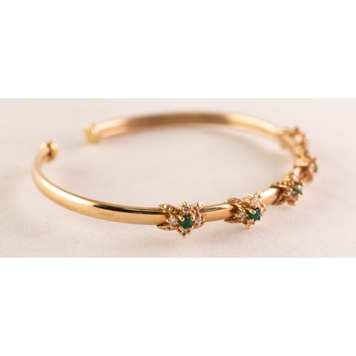 94 - 9ct GOLD NARROW TORQUE BANGLE, the top set with five clusters each with a small centre emerald and s... 