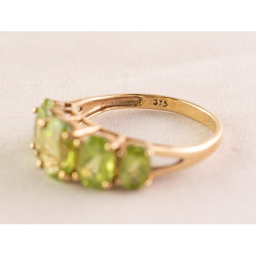 96 - 9ct GOLD DRESS RING set with a row of five oval olivines, each in a four claw setting and graduating... 