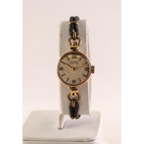 28 - LADY'S VERTEX REVUE 9ct GOLD WRISTWATCH with small circular silvered dial with four arabic numerals ... 