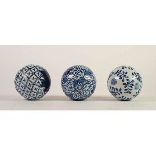 145 - THREE EARLY 20th CENTURY BLUE AND WHITE CERAMIC SPHERICAL BALLS/STRESS BALLS, varying patterns, appr... 