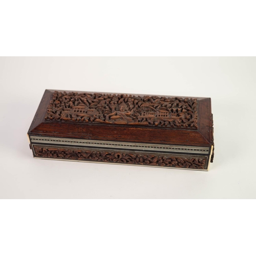32 - EARLY TWENTIETH CENTURY INDIAN CARVED HARDWOOD AND IVORY INLAID OBLONG BOX, the hinge top with well ... 
