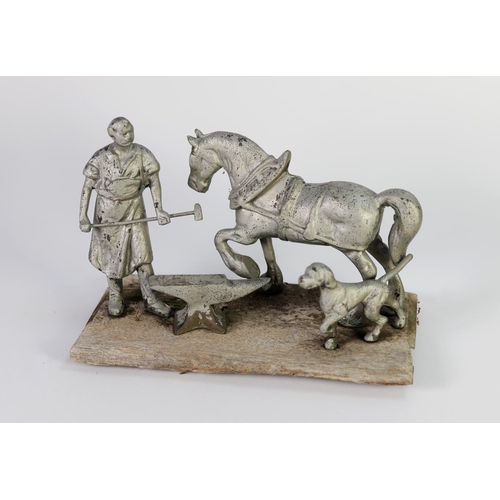 249 - FOUR PIECE SILVER PAINTED CAST METAL GROUP OF A HORSE AND FARRIER, mounted on an oblong wood base, t... 