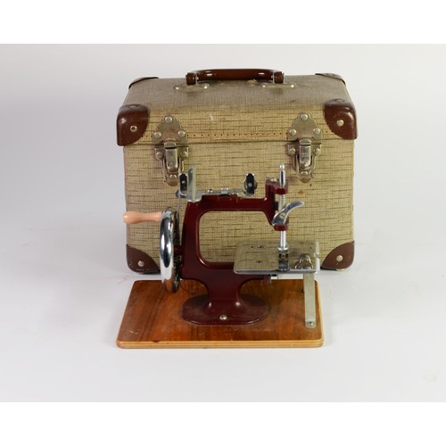 346 - CIRCA 1950s MINIATURE HAND SEWING MACHINE with chromed metal fittings, marooon metal frame, almost m... 