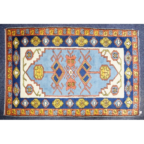 5 - KARS, TURKISH WOOL RUG with geometric triple medallion pattern with pendants on a sky blue field wit... 