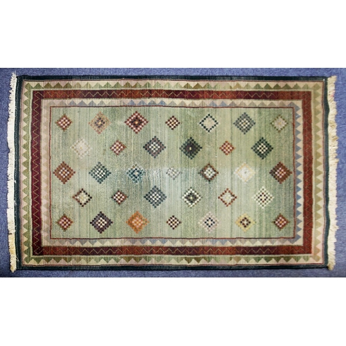 26 - EASTERN SMALLCARPET, machine made with all-over chequered diamond pattern, on a pale green ground, n... 