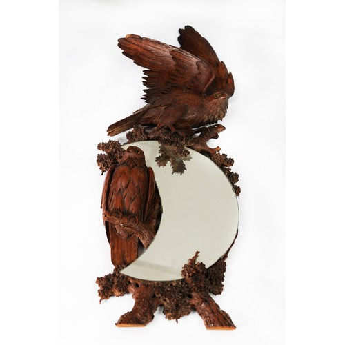 72 - BLACK FOREST STYLE CARVED FRUITWOOD CRESCENT MIRROR, with bas relief carved eagles on naturalistic t... 