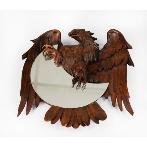 73 - BLACK FOREST STYLE CARVED FRUITWOOD CRESCENT MIRROR, the bas relief carved spread-eagle clasping the... 