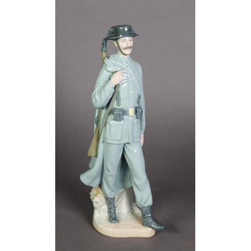 581 - LLADRO, SPANISH PORCELAIN FIGURE OF A SPANISH POLICEMAN, modelled carrying a rifle over his right sh... 