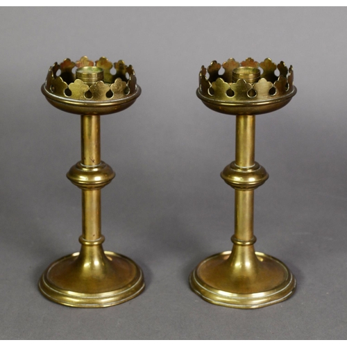 582 - PAIR OF ARTS AND CRAFTS BRASS CANDLESTICKS, each with fancy galleried top above a knopped stem and r... 