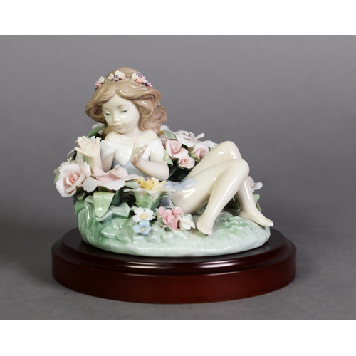 555 - LLADRO, SPANISH PORCELAIN FIGURE OF A NYMPH reclining amongst a bed of flowers, 4 ½” (11.4cm) wide, ... 