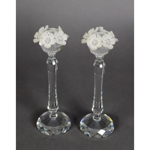 556 - PAIR OF SWAROVSKI CUT CRYSTAL CANDLESTICKS, the sconces each with a garland of frosted glass flowers... 