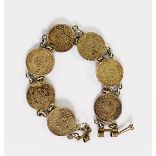 63 - BRACELET COMPRISING 7 KING FARRUK 10 QUIRSH COINS, 1937 - 1939, chain linked, each 20mm in diameter,... 