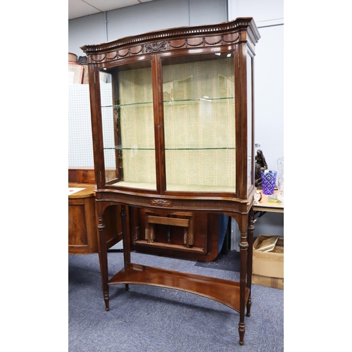 62 - GOOD QUALITY EDWARDIAN SERPENTINE FRONTED, CARVED MAHOGANY DISPLAY CABINET, the dentil moulded corni... 