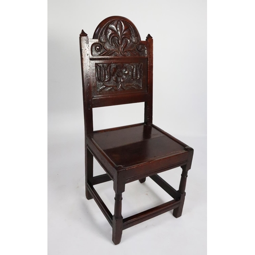 64 - EIGHTEENTH CENTURY CARVED OAK SIDE CHAIR, the panelled back with arced top, carved in relief with st... 