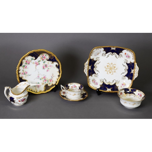 185 - A COLLECTION OF COALPORT TEA AND DINNER WARES, decorated with rose bloom reserves to a royal blue gr... 