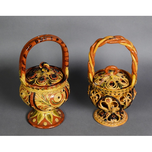 169 - TWO SIMILAR TURKISH RED EARTHENWARE BASKET FORM COVERED STORAGE JARS, with applied simple floral dec... 