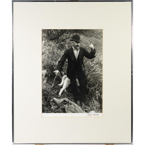 346 - TWO VINTAGE BLACK AND WHITE PHOTOGRAPHIC PRINTS, ONE of a man with dogs amongst ferns, signed BEN HA... 