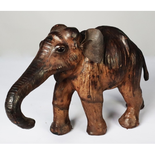 80 - MODERN BROWN LEATHER MODEL OF AN ELEPHANT, modelled with trunk extended, 9” (22.9cm) high