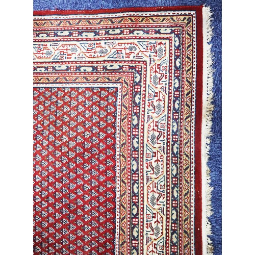 13 - EASTERN CARPET WITH ALL-OVER SMALL BOTEH PATTERN, on a crimson field, off-white and floral meander p... 