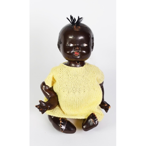 92 - COMPOSITION BLACK BABY DOLL with five-part body, the head with moulded hair and wool top-knot, paint... 