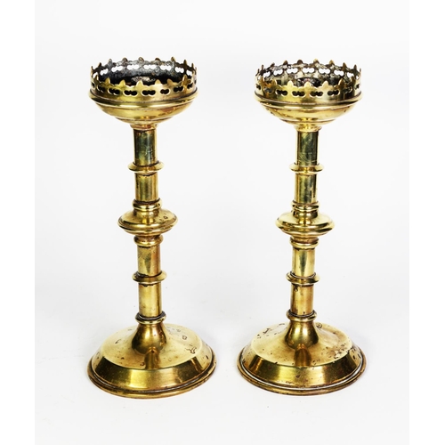 81 - PAIR OF NINETEENTH CENTURY GOTHIC REVIVAL BRASS ALTAR STICKS, each with pierced border and knopped s... 