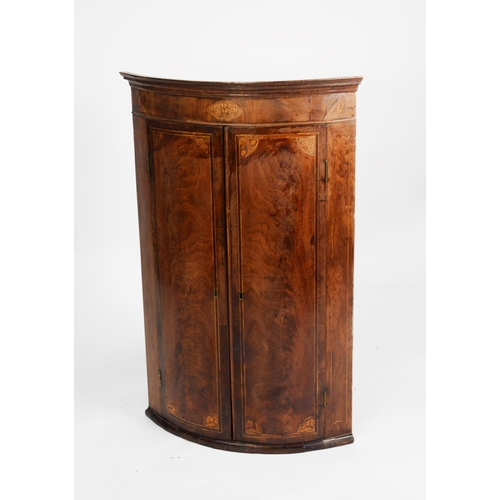 195 - GEORGE III INLAID FLAME CUT MAHOGANY, BOW FRONTED CORNER CUPBOARD, the moulded cornice above a friez... 