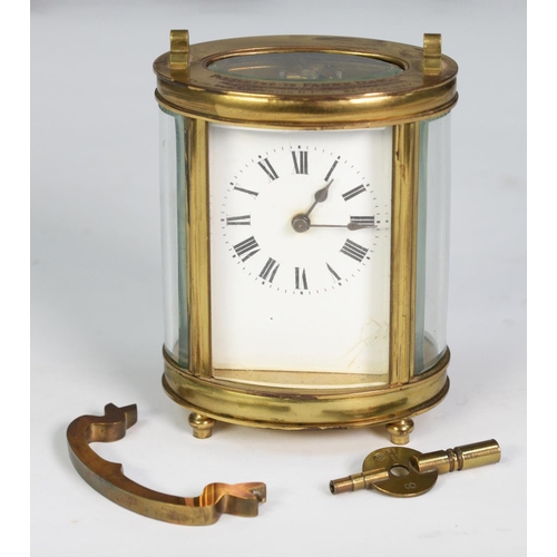 69 - EARLY TWENTIETH CENTURY FRENCH OVAL BRASS PRESENTATION CARRIAGE CLOCK, with top handle, Roman mask a... 