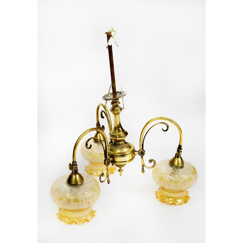 90 - EARLY TWENTIETH CENTURY BRASS THREE LIGHT ELECTROLIER, with scroll arms and amber glass shades with ... 