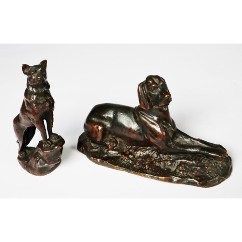 106 - TWO PATINATED BRONZE MODELS OF DOGS, one as a RECLINING LURCHER, 3 ½” (8.9cm) high, 6 ¼” (15.9cm) lo... 