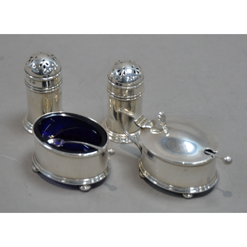 381 - INTER-WAR YEARS SILVER FOUR PIECE CONDIMENT SET comprising a pair of pepperettes, salt cellar and mu... 