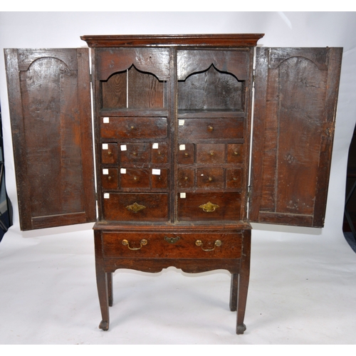 37 - GEORGE III 18th CENTURY OAK SPICE CABINET OR APOTHECARY'S CHEST, on stand, the upper portion with do... 