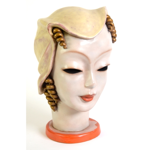 2 - GOLDSCHEIDER, VIENNA, POTTERY HEAD OF A YOUNG WOMAN with ringlets and wearing a hat, on red circular... 