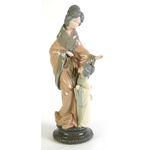 100 - LLADRO PORCELAIN LARGE GROUP, Geisha and child, on black pedestal style base, 15 1/4in (39cm) high