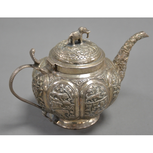 345 - UNMARKED INDIAN EMBOSSED SILVER COLOURED METAL TEAPOT, of footed, globular form with cobra pattern h... 