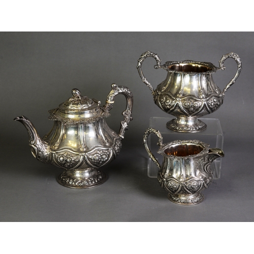 407 - VICTORIAN EMBOSSED SILVER THREE PIECE PEDESTAL TEASET, of bellied form with acanthus capped high scr... 