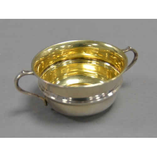 408 - GEORGE V SILVER TWO HANDLED SUGAR BASIN, of girdled for with scroll handles and gilt interior, 2” (5... 