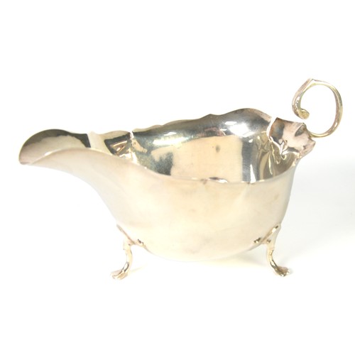 364 - SILVER GEORGIAN STYLE SAUCE BOAT, with cyma edge, free scroll handle, raised on three trefoil feet, ... 