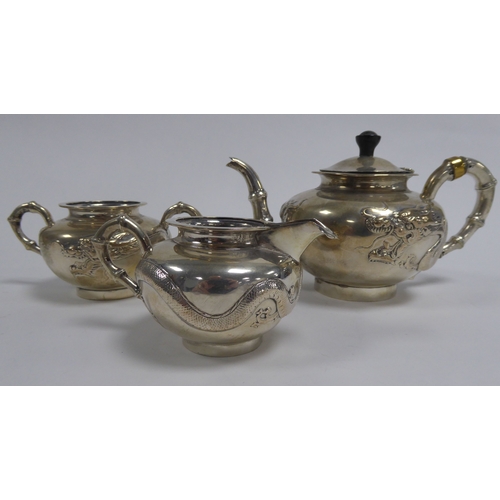 349 - THREE PIECE CHINESE EMBOSSED SILVER COLOURED METAL TEA SET, of compressed, footed form with bamboo p... 