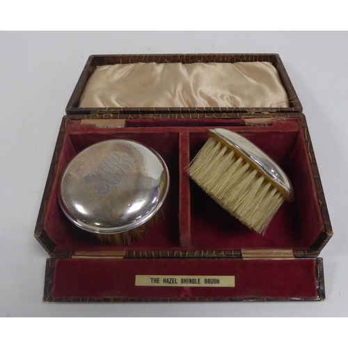 480 - CASED PAIR OF SILVER BACKED ‘HAZEL SHINGLE BRUSHES’, monogrammed, Birmingham 1925