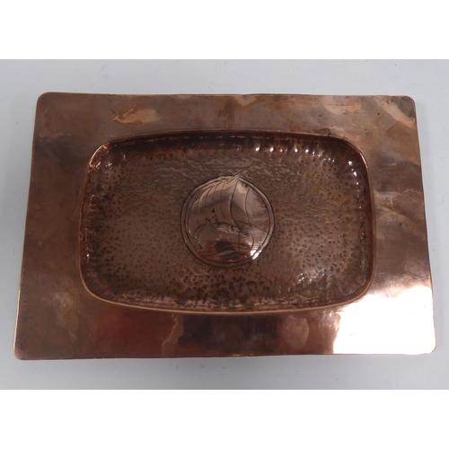 560 - ARTS AND CRAFTS PLANISHED COPPER SMALL OBLONG DISH, with a ship engraved to the dished centre, 8 ¼” ... 