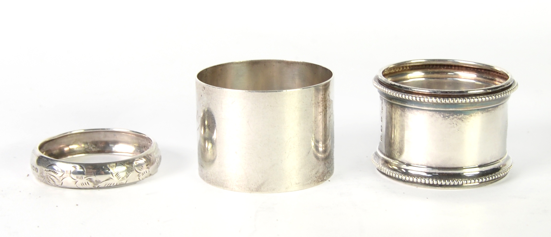 THREE SILVER NAPKIN RINGS, the larger two engraved with names and the ...