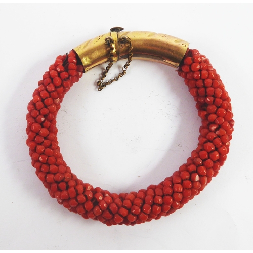 57 - VICTORIAN BRACELET OF MULTIPLE RED CORAL BEADS, with gold plated cylindrical clasp engraved and spir... 