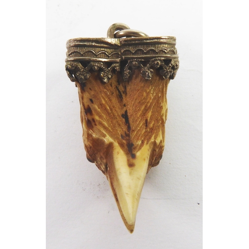 65 - VICTORIAN CARVED BIRD CLAW PENDANT, carved as the head of a bird with tiny glass eyes, with intricat... 