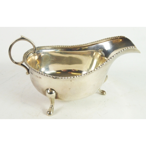 252 - GEORGE VI SILVER SAUCE BOAT, of typical form with flying scroll handle, gadrooned border and pad fee... 